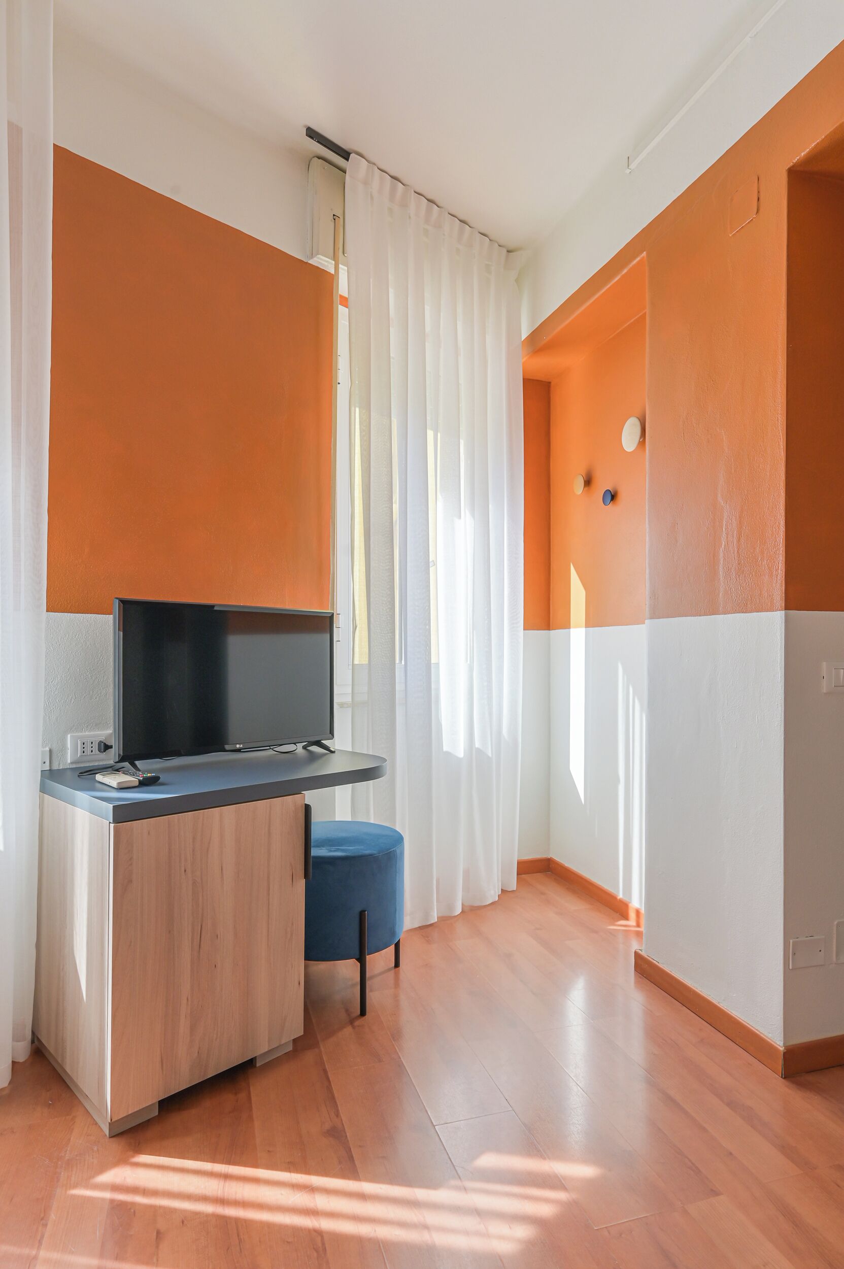 Ein modernes Zimmer mit einem Holztisch, einem Flachbildfernseher und einem blauen Stuhl.
