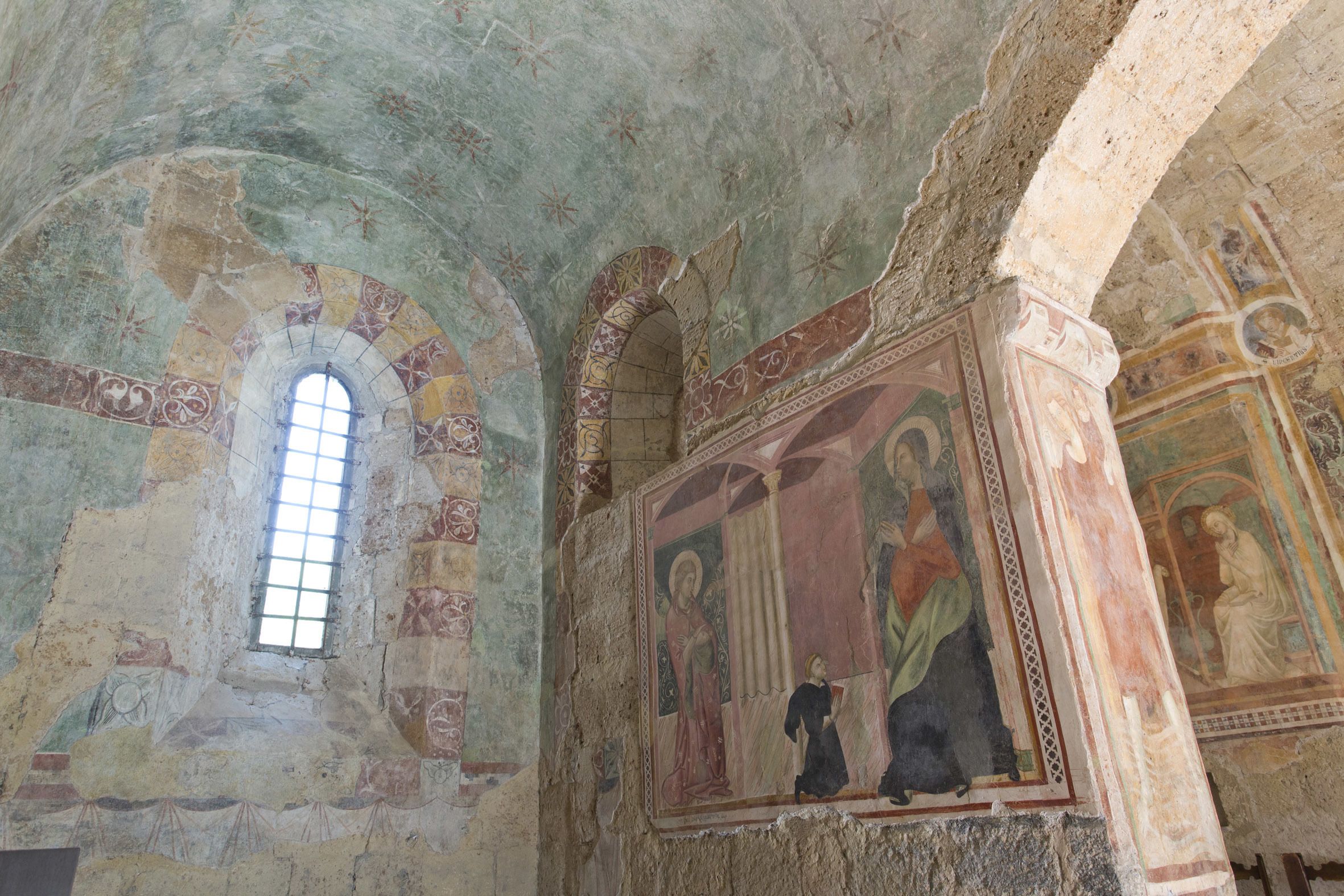 Un interior con techos abovedados y frescos.