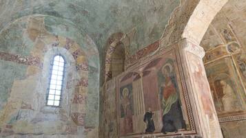 Un interior con techos abovedados y frescos.