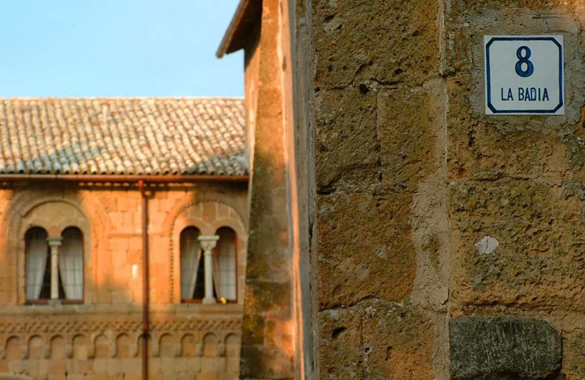 A stone building with a sign reading "8 LA BADIA".