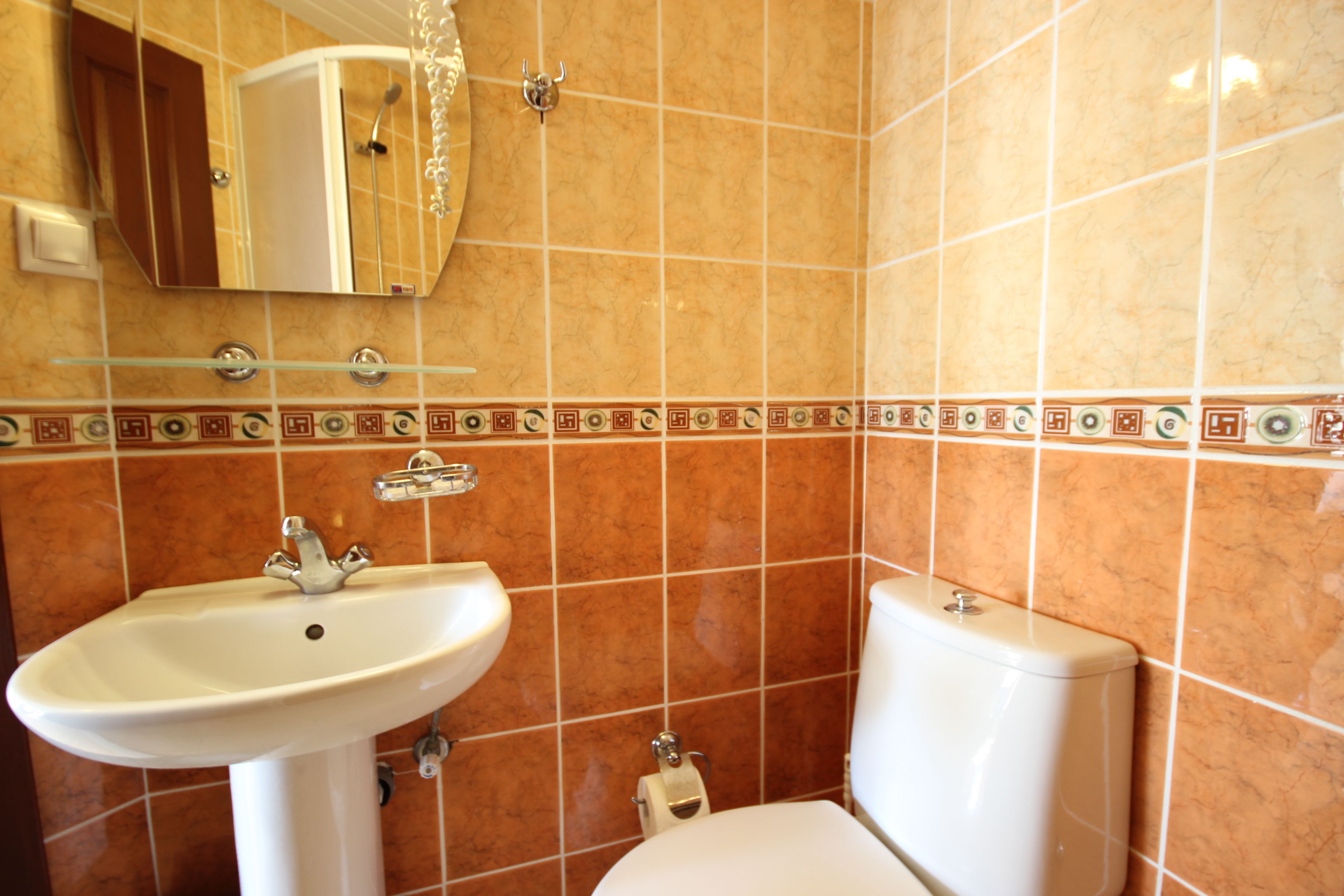 Un baño con lavamanos, inodoro y espejo.