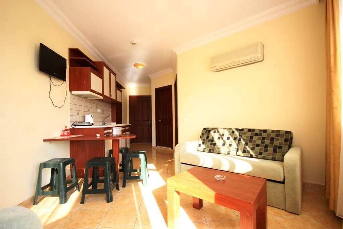A compact living space with a kitchenette, a sofa, and a coffee table.
