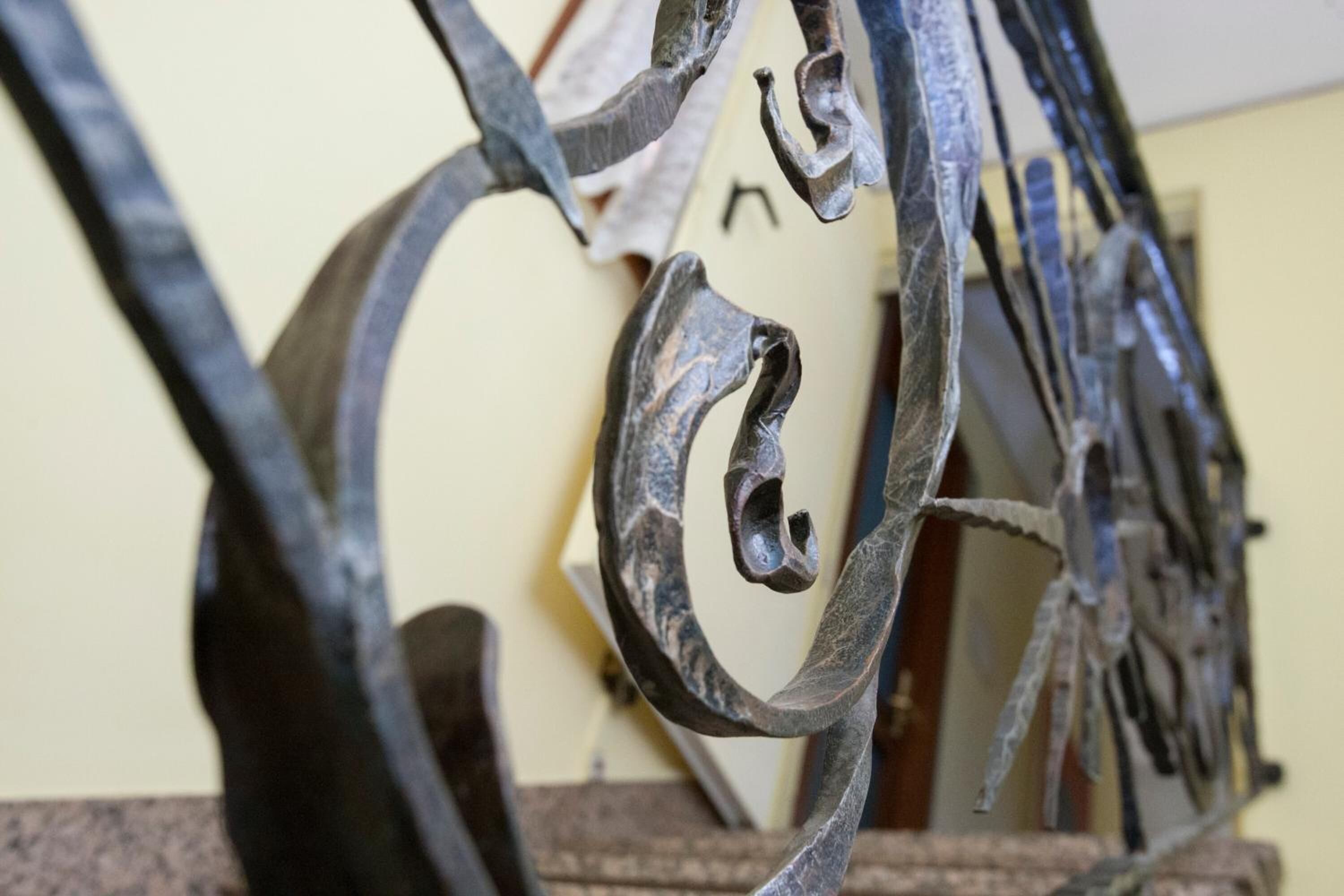 Primer plano de una escultura metálica con formas y curvas abstractas.