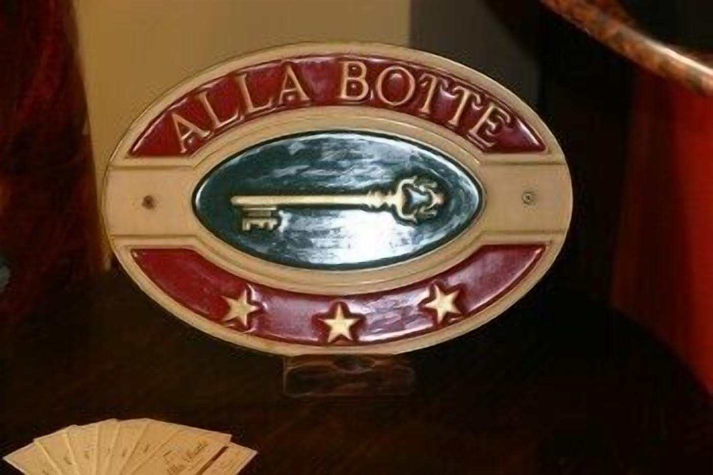 A poker table with a sign that reads "ALLA Botte" and a poker chip holder.