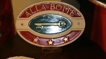 A poker table with a sign that reads "ALLA Botte" and a poker chip holder.
