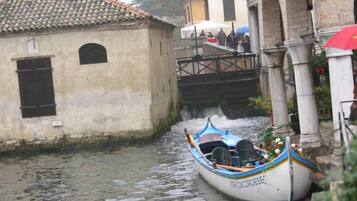 A narrow canal with a boat docked at a stone building.