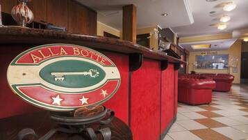 A reception desk with a vintage design, a sign reading "ALLA BOTTTE," and a check-in counter.