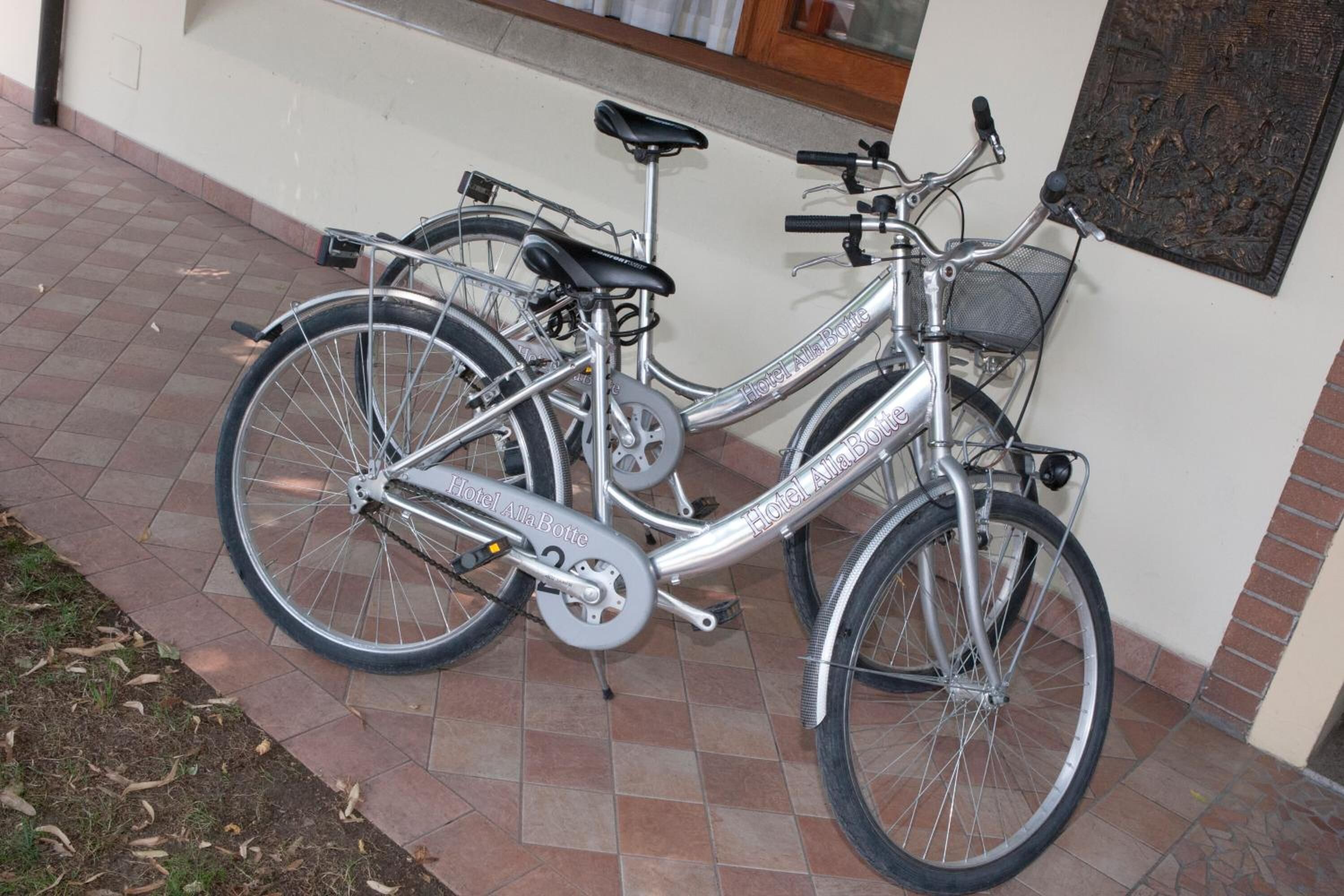 A silver bicycle with "Hotel Alia Boutique" branding parked on a tiled patio.
