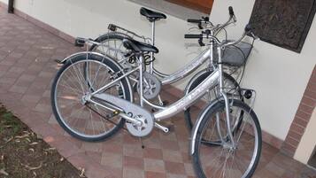 A silver bicycle with "Hotel Alia Boutique" branding parked on a tiled patio.