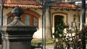 Eine Steinschilderkanzel in einem Innenhof, im Hintergrund ein Gebäude mit einem Ziegeldach und Bogenfenstern.