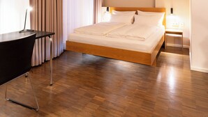 A bedroom with a brick ceiling, a bed, a desk, and a nightstand. - Hotel Johann (Berlin)