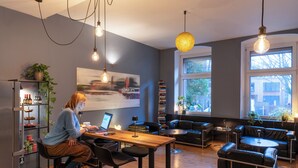 A modern interior with a wooden table, black leather seating, and a large window with a view. - Hotel Johann (Berlin)
