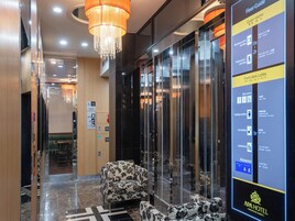 Un hall de hotel con un plano de la planta, una recepción y un restaurante.