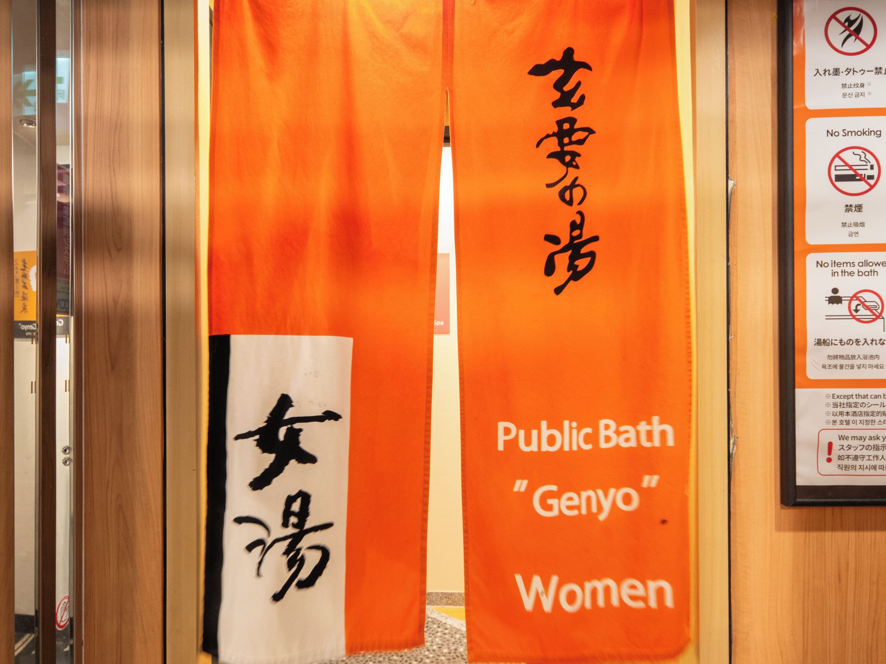 L’entrée d’un établissement de bains publics, avec des banderoles en japonais et en anglais, ainsi qu’un panneau indiquant qu’il est interdit de fumer.