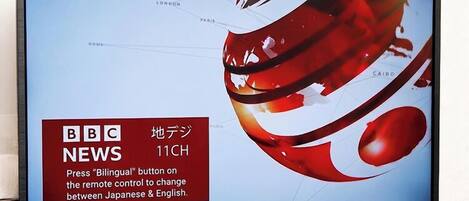 Un televisor mostrando las noticias de BBC 11CH con un diseño abstracto rojo en la pantalla.