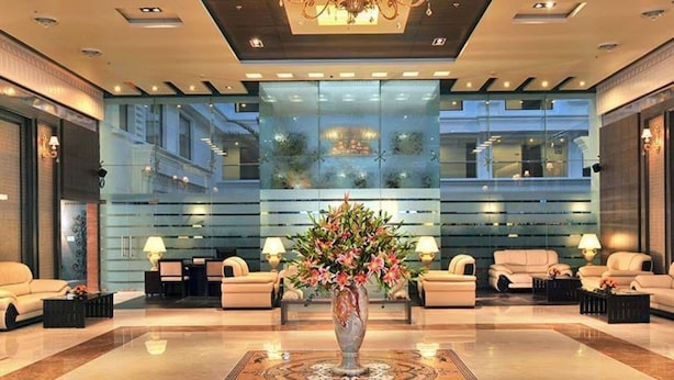 A spacious lobby with a central floral arrangement, comfortable seating, and a modern chandelier. - Fortune JP Palace, Mysore - Member ITC Hotels' Group (Mysore)