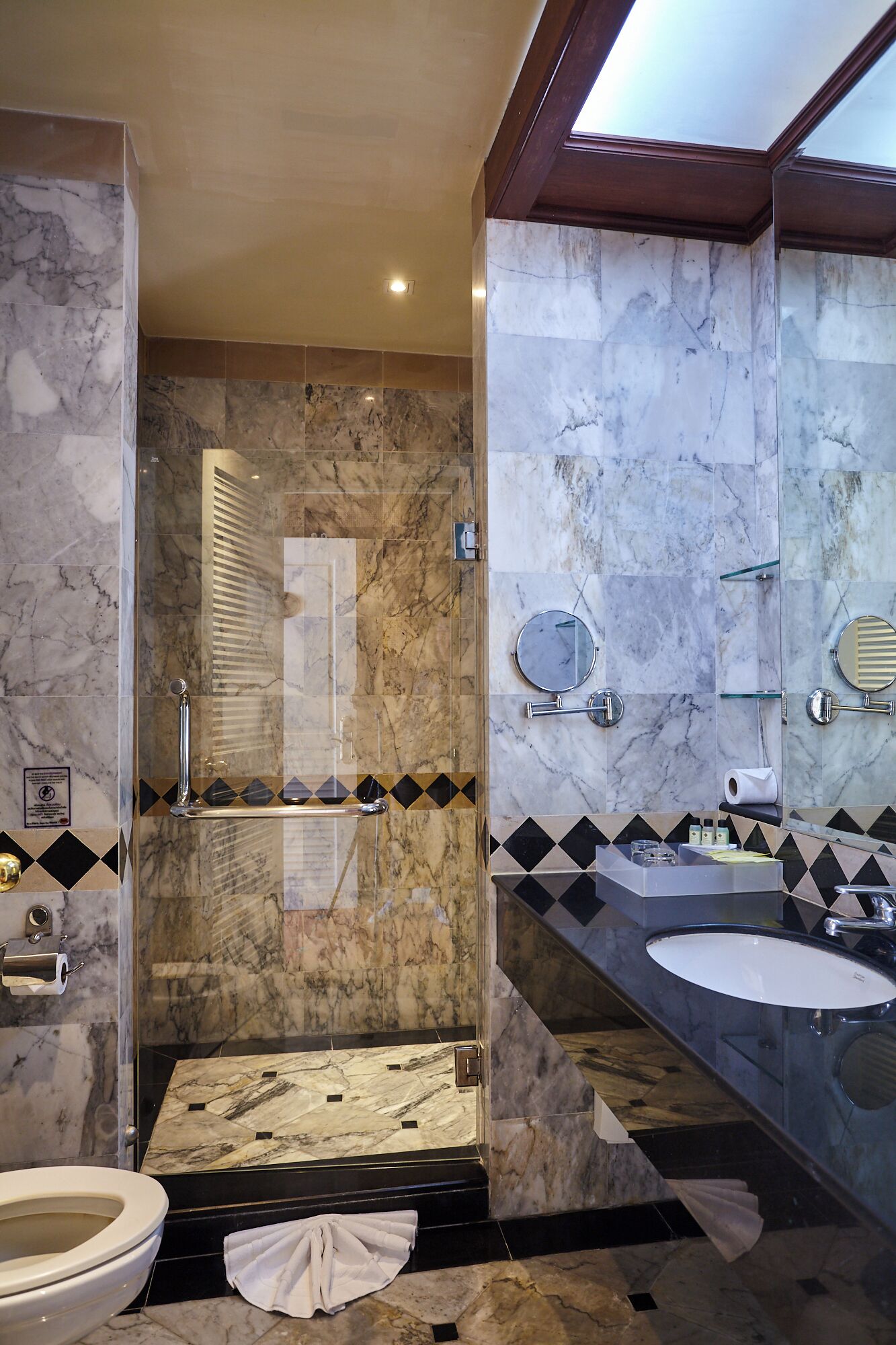 A modern bathroom with a shower, two sinks, and a large mirror.