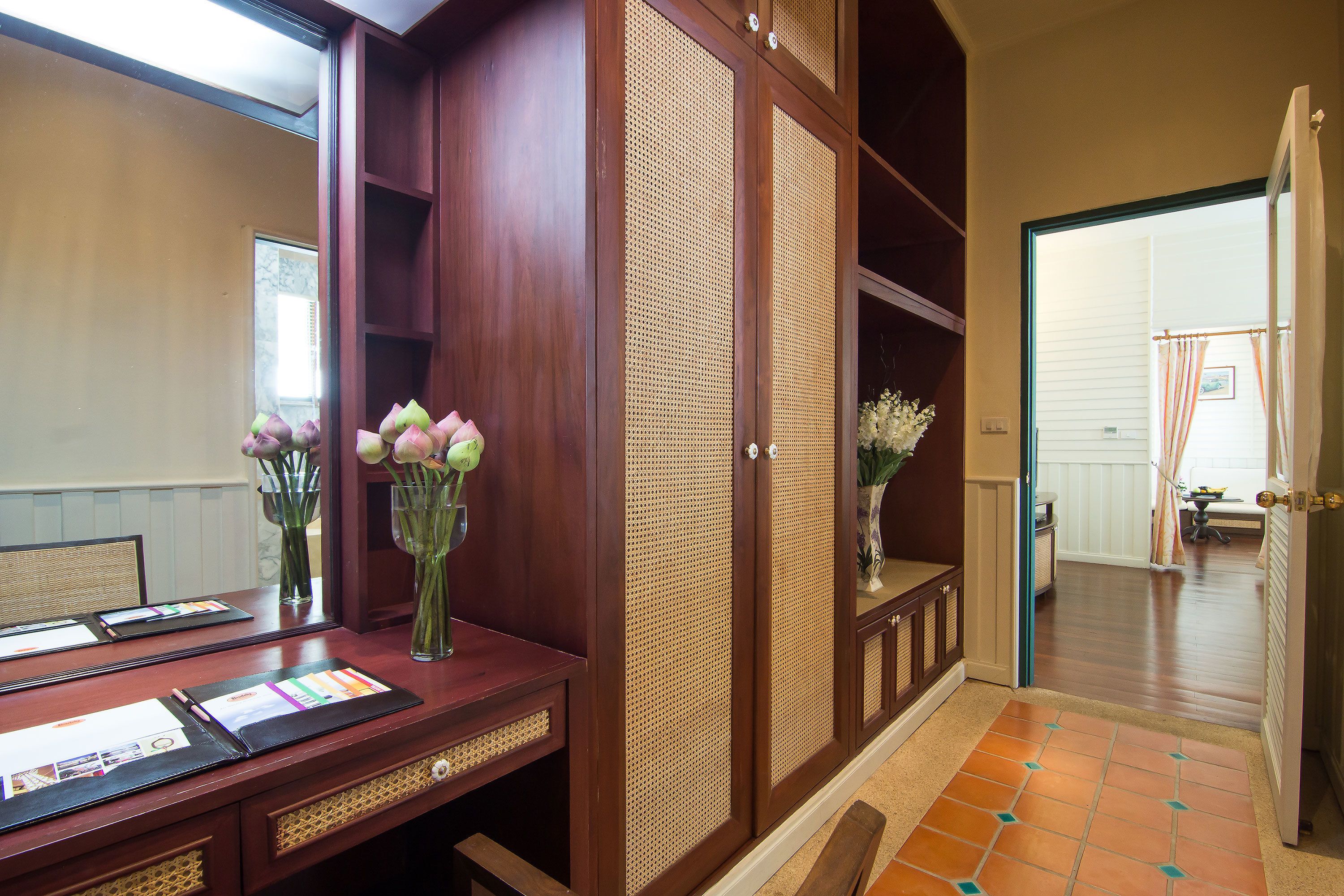 Ein Hotel-Empfangsbereich mit einem Holztresen, Broschüren und Blumenvasen.