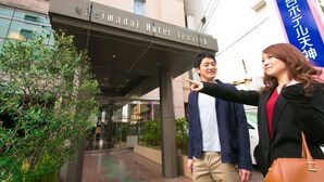 L’entrée de l’hôtel Heiwa Tenjyo se distingue par sa façade moderne et une enseigne bien visible.