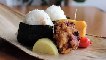 A plate with sushi, a fried item, and a small red object.