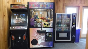 Three arcade machines in a room with wooden walls. - Rangeley Lake Resort (Rangeley)