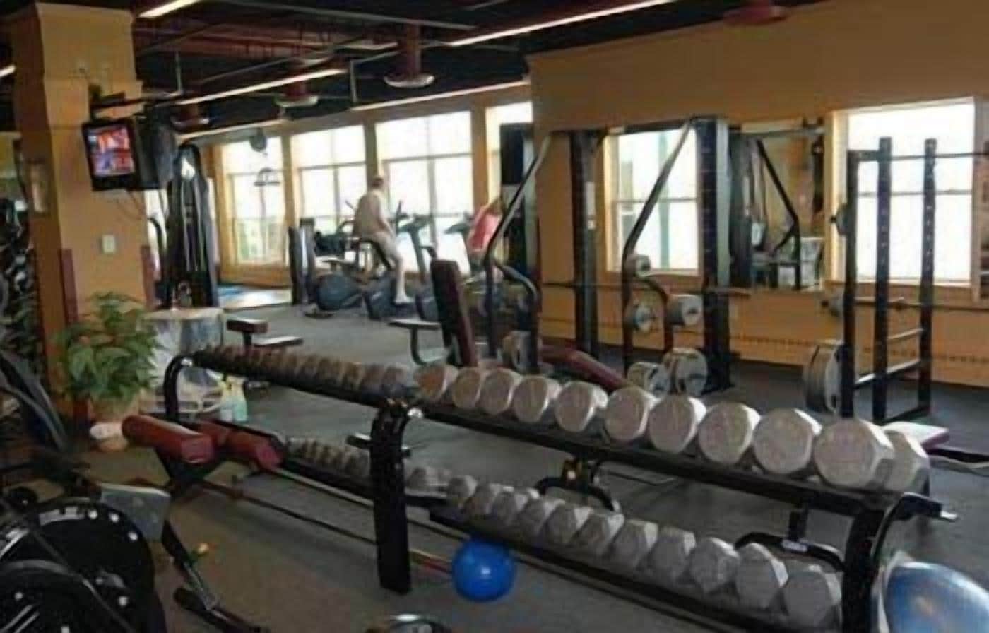 A gym with exercise equipment, including dumbbells and a treadmill.