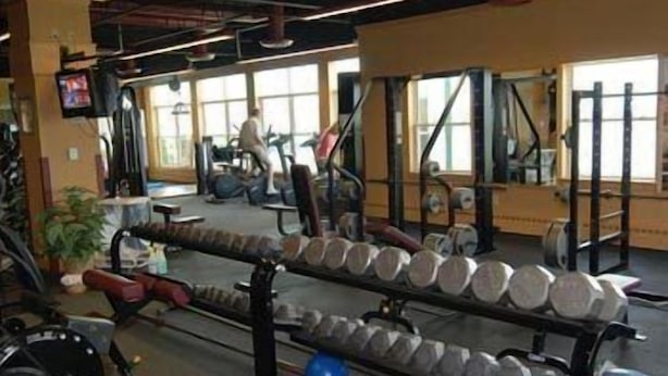 A gym with exercise equipment, including dumbbells and a treadmill. - Rangeley Lake Resort (Rangeley)
