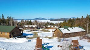 A lodge with multiple cabins, a covered outdoor area, and a view of distant mountains.