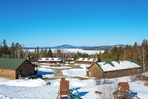A lodge with multiple cabins, a covered outdoor area, and a view of distant mountains.