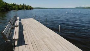 A wooden dock extending into a calm lake with a clear sky. - Rangeley Lake Resort (Rangeley)