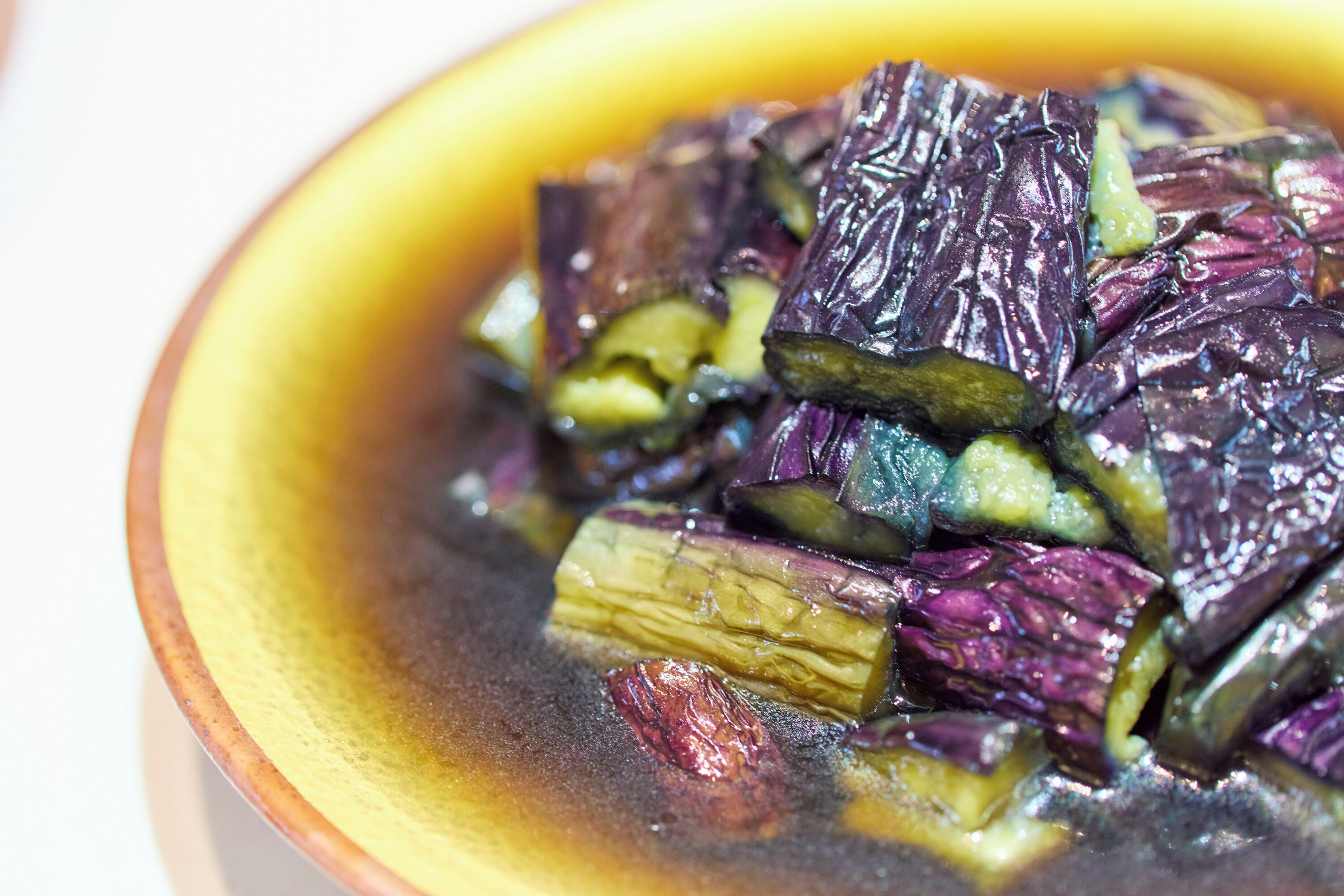 Un plato de verduras cocidas con un borde amarillo.