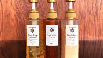 Three bottles of shower break products with pumps, labeled 'Body Soap,' 'Shampoo,' and 'Conditioner,' each with a volume of 300mL or 10FL.oz.