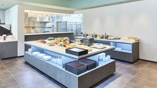 A modern kitchen with a central island, stainless steel appliances, and a clean, organized layout.
