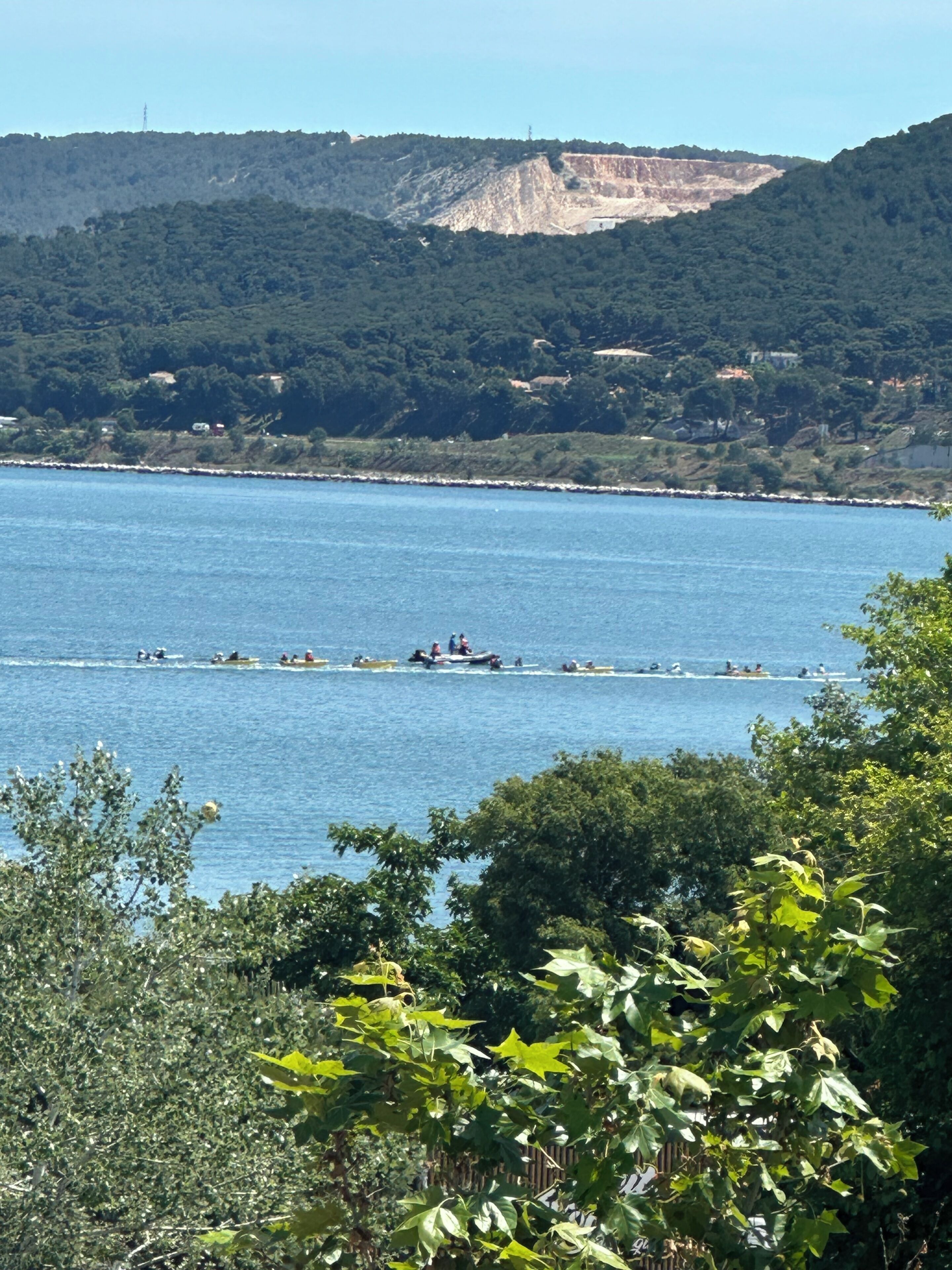 Un paisaje costero con una vista despejada del mar, un acantilado rocoso y abundante vegetación.