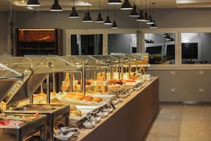 A buffet with various food items, glass display cases, and overhead lighting.