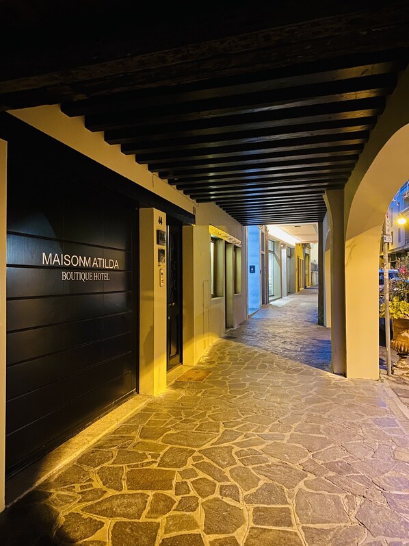 A stone-paved corridor with a black door labeled "MAISONMATILDA BOUTIQUE HOTEL". - Maison Matilda (Treviso)