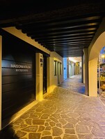Un pasillo empedrado con una puerta negra que indica 