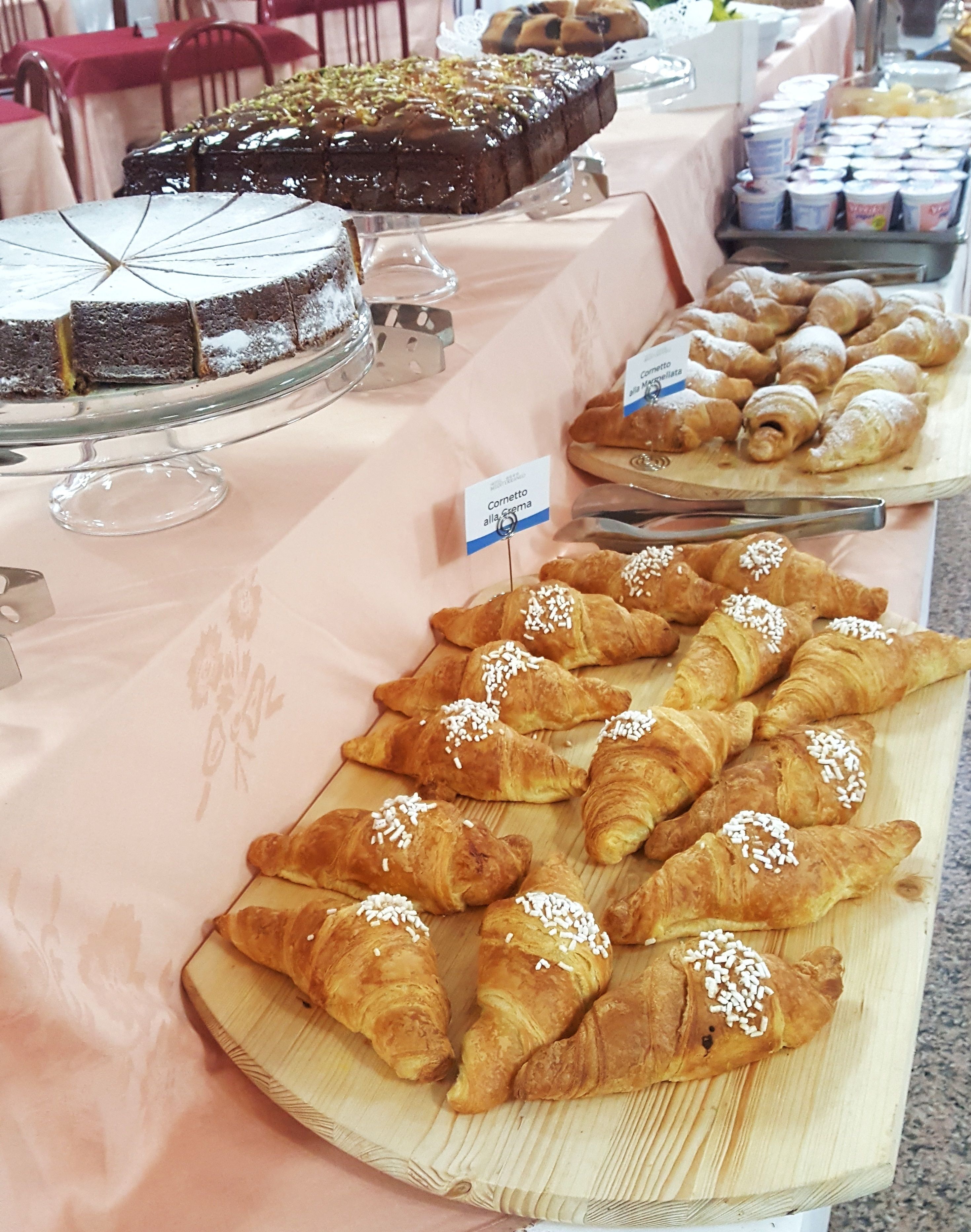 A buffet table with various baked goods including cakes and pastries.