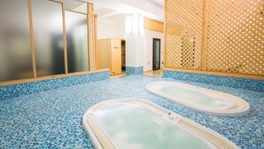 Área de spa com duas banheiras de hidromassagem e um divisória de madeira.