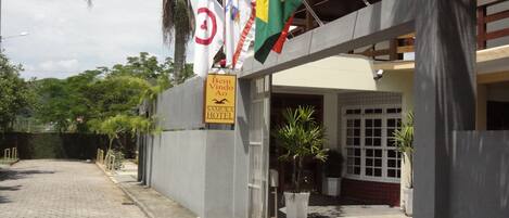 A hotel entrance with a sign reading "Bem Vindo Ao SAMUKA HOTEL".