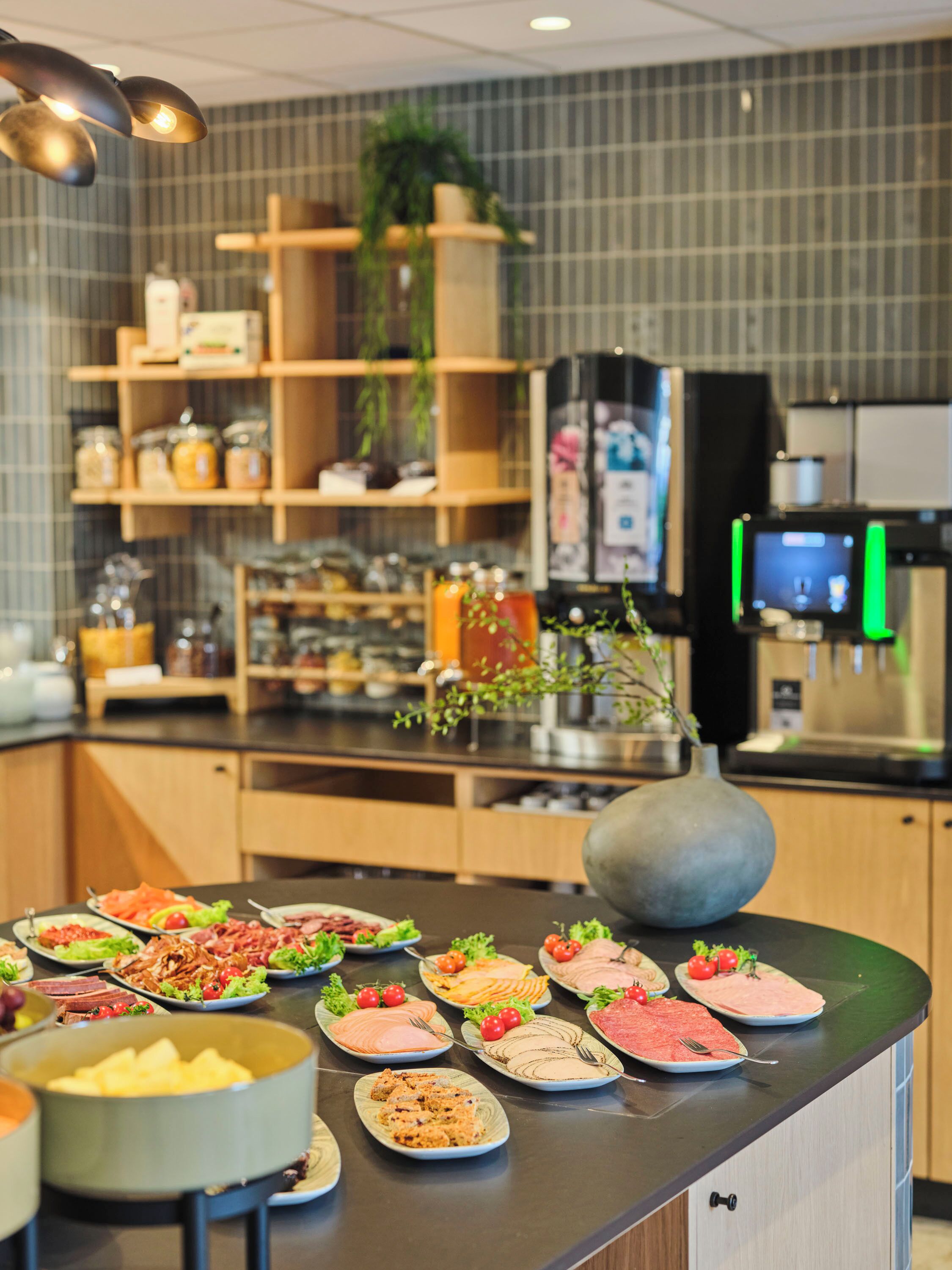 A buffet setup with various food items and a modern kitchen in the background.
