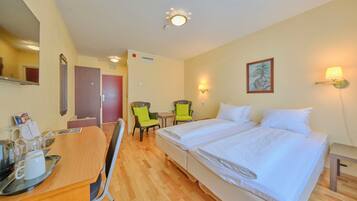 Habitación de hotel con cama, escritorio, sillas y un cuadro en la pared.