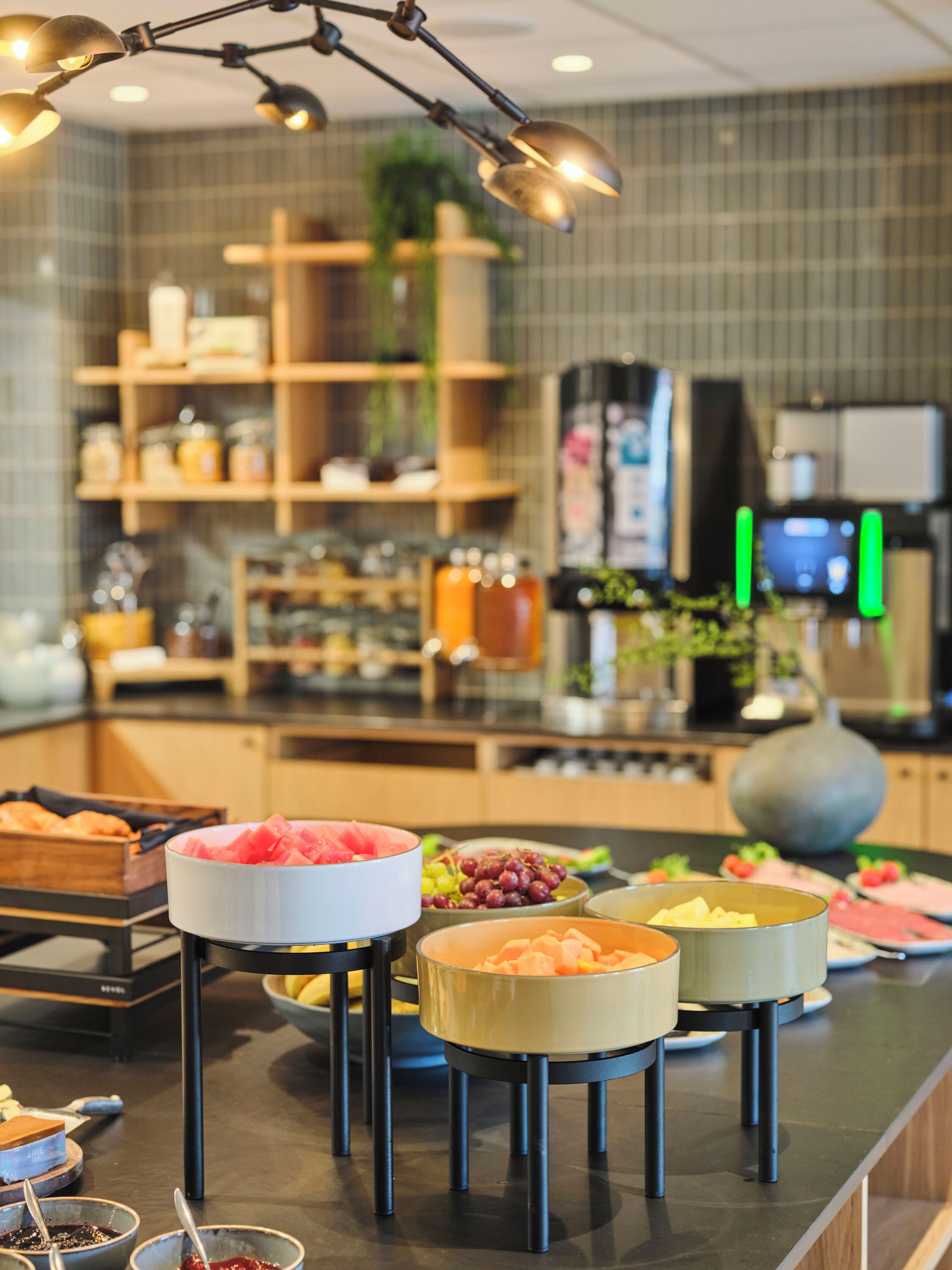 A buffet setup with various food items and a modern kitchen in the background.