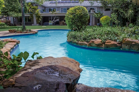 Una piscina al aire libre, sombrillas