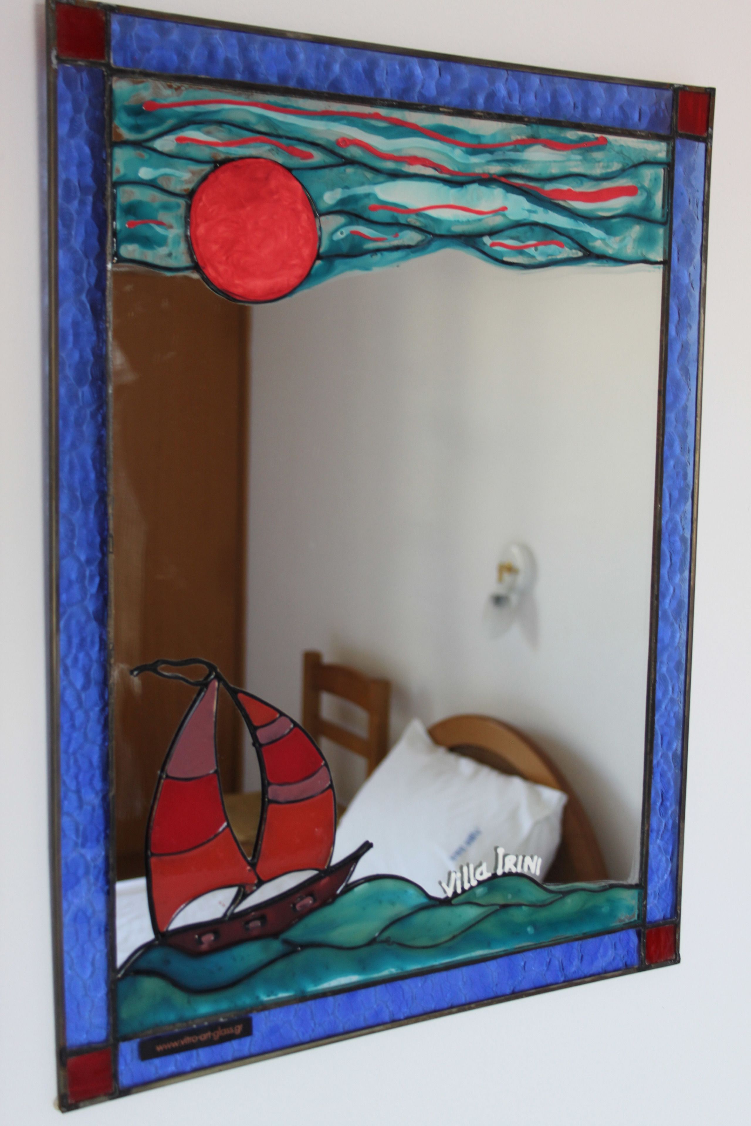 Een spiegel met een glas-in-lood ontwerp waarop een zeilboot en golven afgebeeld zijn.