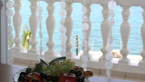 Un balcon doté d’une balustrade blanche et offrant une vue sur la mer.