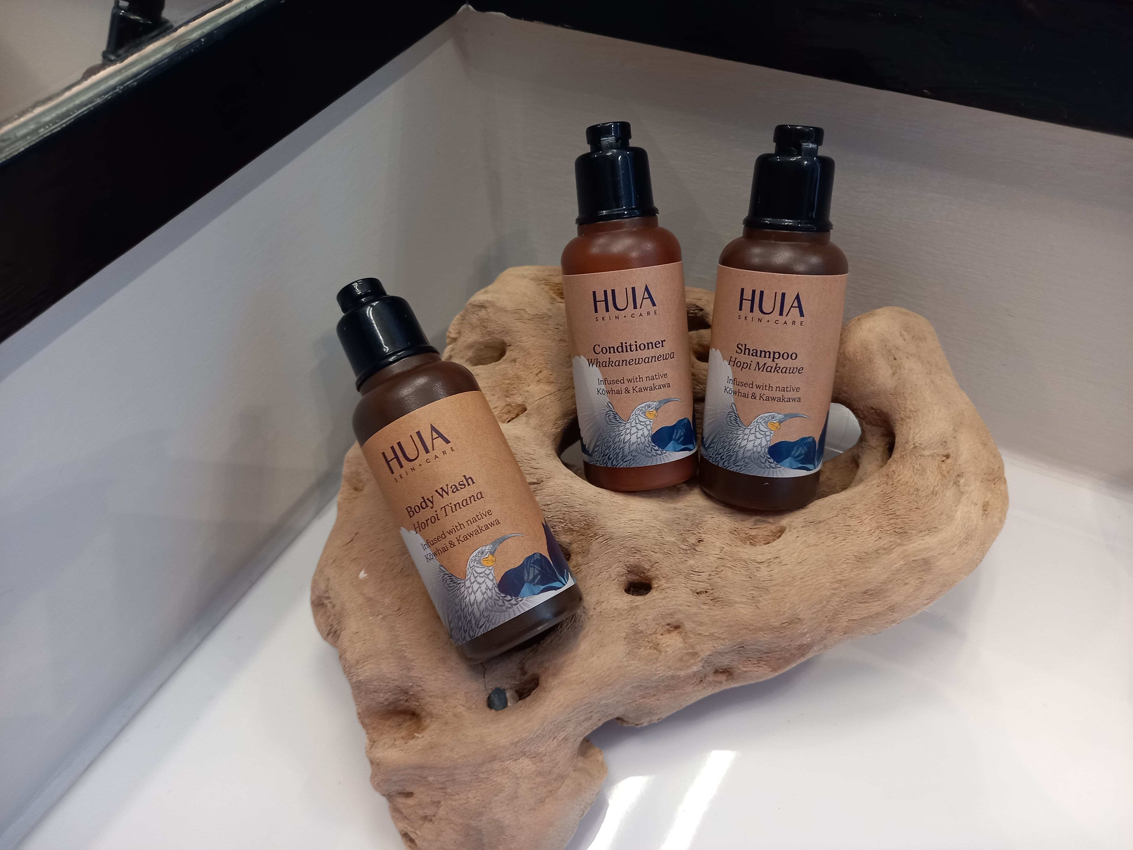 Drei HUIA Hautpflegeprodukte in einem Waschbecken.