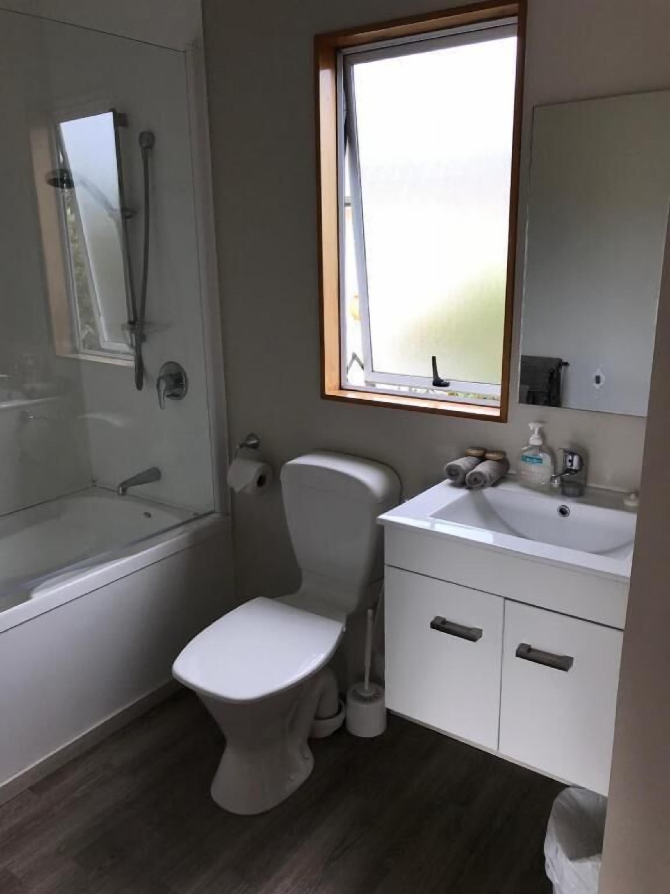 Un baño con inodoro, lavamanos y ducha.