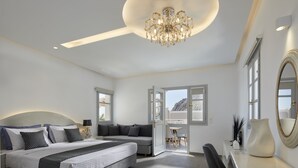 Un dormitorio moderno con cama, sofá, zona de comedor y candelabro.
