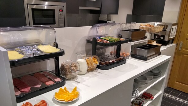 A buffet with various food items including meats, cheeses, fruits, and beverages. - Mstay Russell Court Hotel (London)